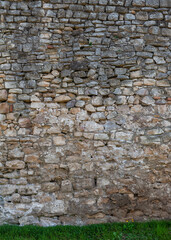 Old ancient brick stone wall texture background with grass