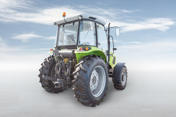 Modern wheeled tractor isolated on bright background with sky