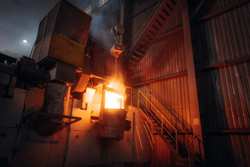 Molten metal pouring in an industrial foundry Intense heat and sparks illuminate the scene
