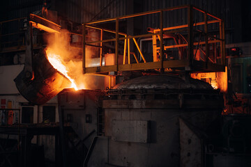 Obraz premium Molten metal being poured into a furnace in a metal foundry