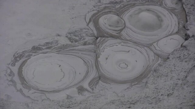 Blubbernde Schlammfumarole, Schlammtopf, hei&szlig;e Quelle, Schlammblase, vulkanischer Schlamm, grauer, dampfender Schlammtopf in Island, Geothermie, vulkanische Aktivit&auml;t