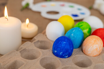 Colorful Easter egg decorating activity with candles and floral decorations in spring setting