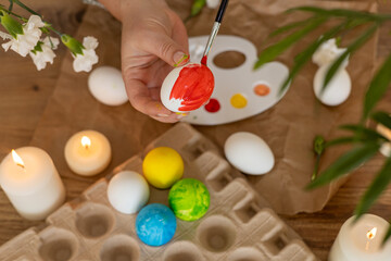 Decorating colorful Easter eggs with a palette and candles during spring festivities