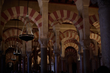 The interior of the Mosque-Cathedral of Córdoba, featuring its iconic columns and horseshoe arches, a masterpiece of Moorish and Spanish architecture in Andalusia, Spain