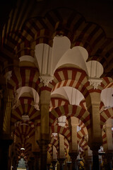 The interior of the Mosque-Cathedral of Córdoba, featuring its iconic columns and horseshoe arches, a masterpiece of Moorish and Spanish architecture in Andalusia, Spain
