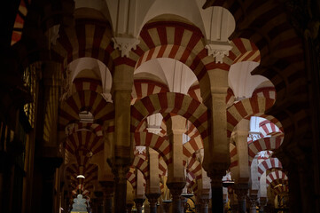 The interior of the Mosque-Cathedral of Córdoba, featuring its iconic columns and horseshoe arches, a masterpiece of Moorish and Spanish architecture in Andalusia, Spain