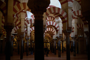 The interior of the Mosque-Cathedral of Córdoba, featuring its iconic columns and horseshoe arches, a masterpiece of Moorish and Spanish architecture in Andalusia, Spain