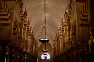 The interior of the Mosque-Cathedral of Córdoba, featuring its iconic columns and horseshoe arches, a masterpiece of Moorish and Spanish architecture in Andalusia, Spain