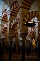 The interior of the Mosque-Cathedral of Córdoba, featuring its iconic columns and horseshoe arches, a masterpiece of Moorish and Spanish architecture in Andalusia, Spain