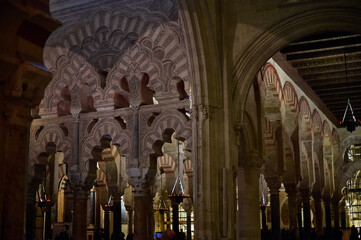 The interior of the Mosque-Cathedral of Córdoba, featuring its iconic columns and horseshoe arches, a masterpiece of Moorish and Spanish architecture in Andalusia, Spain