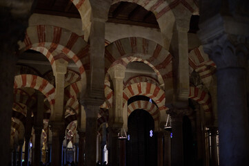 The interior of the Mosque-Cathedral of Córdoba, featuring its iconic columns and horseshoe arches, a masterpiece of Moorish and Spanish architecture in Andalusia, Spain
