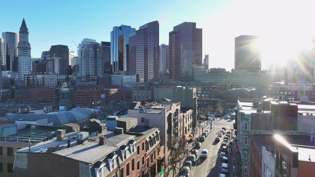 Boston&rsquo;s skyline with sunlight reflecting off skyscrapers. Historic buildings line Hanover Street in the North End. Aerial reveal of Custom House Tower and downtown.