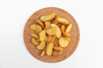 Fried potatoes on a wooden plate isolated on a white background.