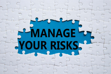 Risks symbol. Concept words Manage your Risks on white puzzle. Beautiful blue background Business...