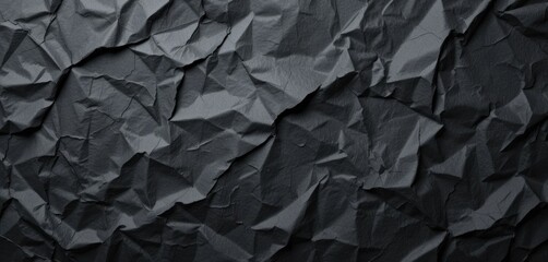 Dark crumpled paper with visible folds and creases abstract dark textured background for creative use