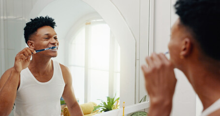 Bathroom, house and man brushing teeth, reflection and hygiene with morning routine. Person, mirror and grooming with toothbrush, fresh breath or cleaning mouth with dental health, smile or whitening