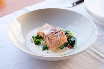 Pan seared fish fillet atop creamy spinach and broccoli
