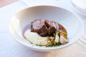 Braised meat with creamy mashed potatoes and sautéed vegetables