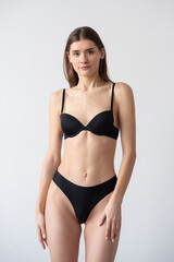 Fototapeta premium High-quality model polaroid featuring a tall, fit woman in a minimalistic studio environment. Showcasing a neutral expression, toned physique, and poised posture for fashion industry standards.