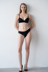 Fototapeta premium Casting snapshot of a fresh-faced model in simple black underwear, highlighting her natural features, body proportions, and confident stance. Ideal for agency scouting and professional portfolio updat