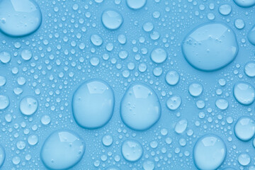 Cosmetic moisturizing liquid drops on blue pastel background. Toner or lotion. Hyaluronic serum