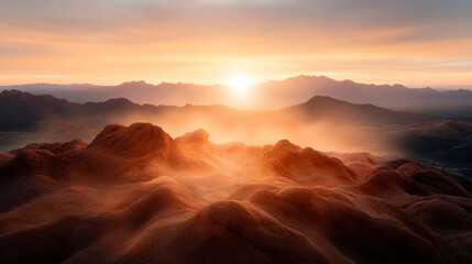 Naklejka premium The sun sets behind ethereal mountain peaks, creating a misty atmosphere that envelops the landscape in a dreamy, tranquil ambiance of nature's beauty.