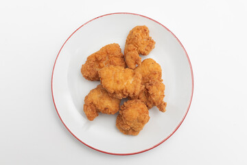 Fried chicken wings on a plate on a white background, close-up