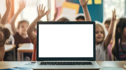 Laptop computer white blank empty mockup screen on teachers table with elementary junior children students raising hands in classroom background. Education software website technology ads concept.