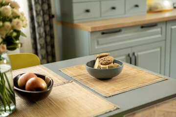 A cozy kitchen table setting with a bowl of cookies and wafers
