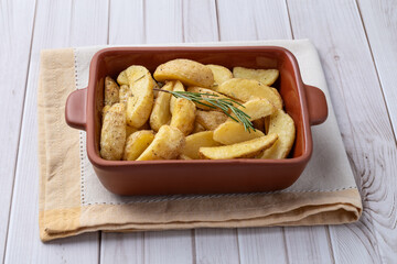 Rustic baked potatoes in a plate over wooden table