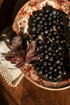Rustic autumn still life with blueberries and decorative plate