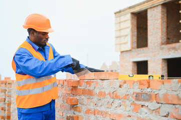 Construction african american worker in uniform and safety equipment have job on building.