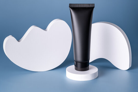 Modern cosmetic tube on stylized podium in studio setting