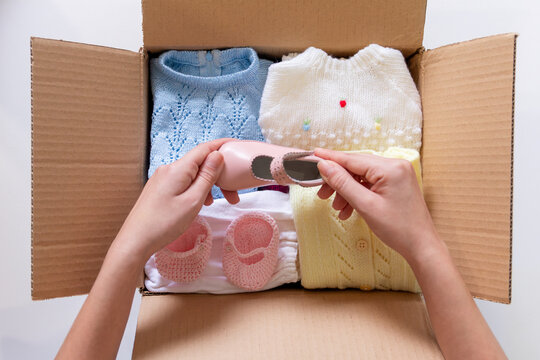 Sorting Baby Clothes for Sale in a Cardboard Box