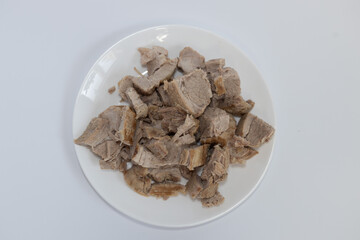 cooking: boiled cut meat on a plate on a white background