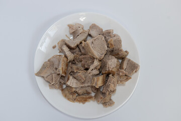 cooking: boiled cut meat on a plate on a white background