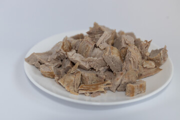 cooking: boiled cut meat on a plate on a white background