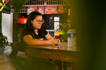 Colombian waitress using smartphone in restaurant during break time