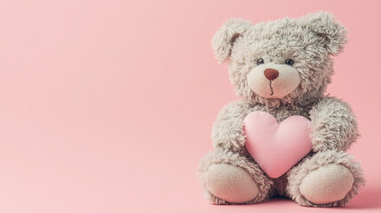 Cute fluffy teddy bear holding a plush pink heart on pink background. Valentine holiday charity...