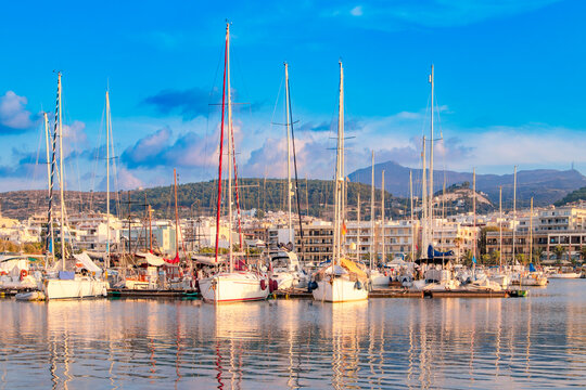 Greece. Rethymnon. Beautiful cityscape port, arsenal, modern buildings, yachts, azure sea water on the background of stormy sky at evening, harbor.