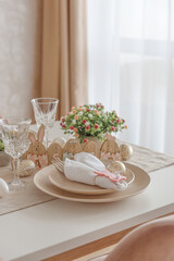 Festive Easter table setting with Easter bunny made from napkin. Easter celebration concept