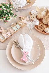 Festive Easter table setting with Easter bunny made from napkin. Easter celebration concept. Top view