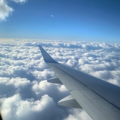 Obraz premium Wing of an airplane gliding above soft, white clouds under a clear blue sky during daylight. Generative AI