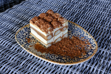A delectable slice of tiramisu layered with creamy goodness and cocoa powder