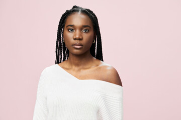 Portrait of a young Black woman with braided hair wearing a white off shoulder sweater against a...