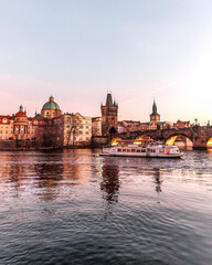 Obraz premium Sunset colors in Prague Historical Gothic Medieval castle, St. Vitus Cathedral, Charles Bridge and river Vltava boat cruise, astronomical clock, Unesco city tourism, golden hour and water reflection