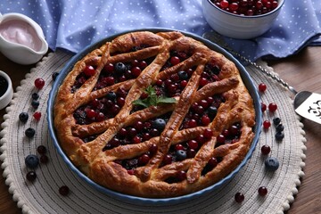 Delicious currant pie with fresh berries on wooden table