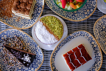 Assortment of delicious desserts on patterned plates