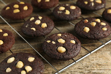 Tasty chocolate cookies with hazelnuts on wooden table, closeup