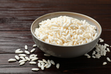 Puffed rice in bowl on wooden table, closeup